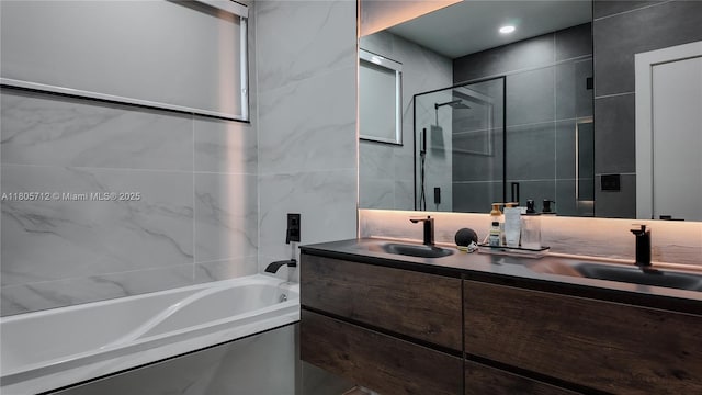 full bath with an enclosed shower, a bath, double vanity, and tile walls
