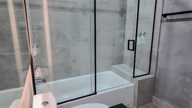 bathroom featuring enclosed tub / shower combo and toilet
