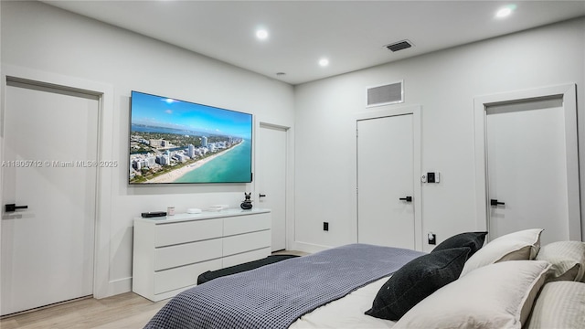 bedroom with light wood finished floors and recessed lighting