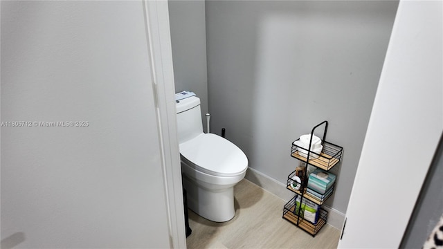 bathroom featuring wood finished floors, toilet, and baseboards
