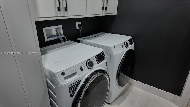 laundry area featuring cabinet space, independent washer and dryer, and tile patterned flooring