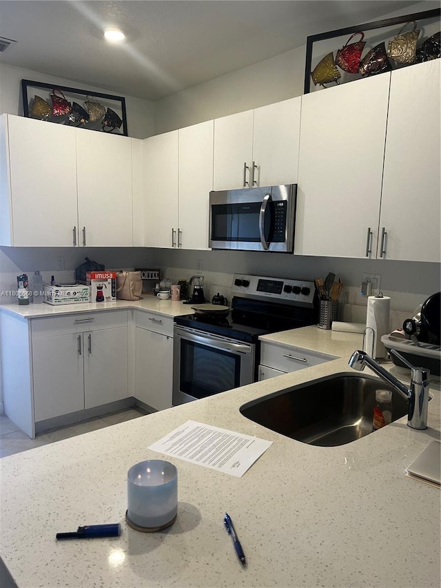12956 SW 286th Ter, Homestead, FL 33033 - kitchen with appliances with stainless steel finishes, a sink, white cabinets, and light stone counters