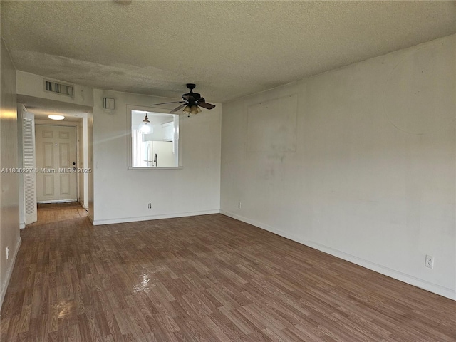 8620 N Sherman Cir Unit 202, Miramar, FL 33025 - spare room with wood finished floors, a ceiling fan, baseboards, and a textured ceiling