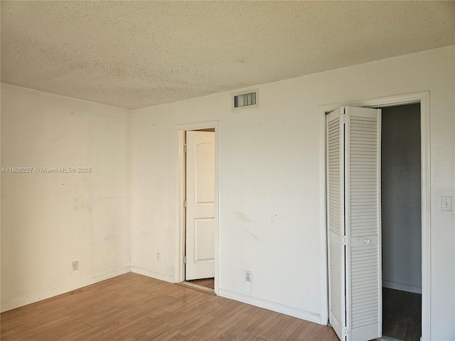 8620 N Sherman Cir Unit 202, Miramar, FL 33025 - unfurnished bedroom with wood finished floors, a textured ceiling, baseboards, and a closet