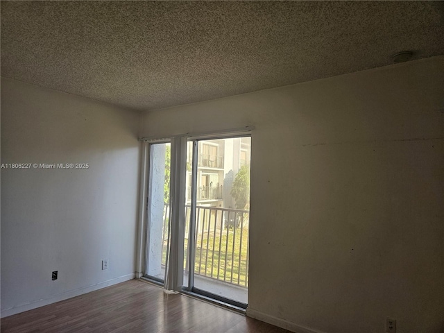 8620 N Sherman Cir Unit 202, Miramar, FL 33025 - empty room featuring wood finished floors, baseboards, and a textured ceiling