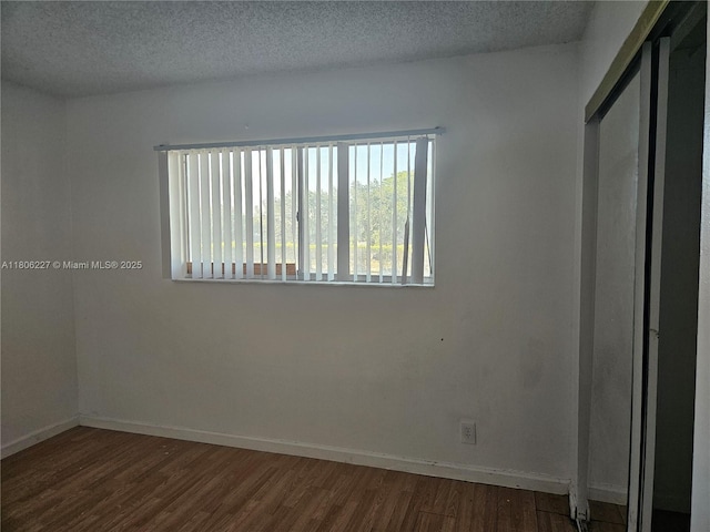 8620 N Sherman Cir Unit 202, Miramar, FL 33025 - unfurnished bedroom with dark wood finished floors, baseboards, and a textured ceiling