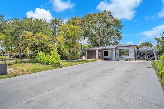 1635 NE 174th St, North Miami Beach, FL 33162 - view of front of home featuring a standing seam roof, concrete driveway, and metal roof
