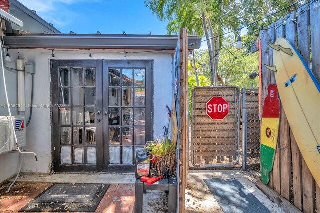 1635 NE 174th St, North Miami Beach, FL 33162 - doorway to property featuring french doors, a gate, and stucco siding