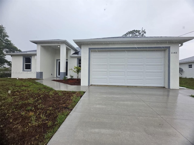 1145 SW Antonio St E, Lehigh Acres, FL 33974 - view of front facade with stucco siding, concrete driveway, and an attached garage