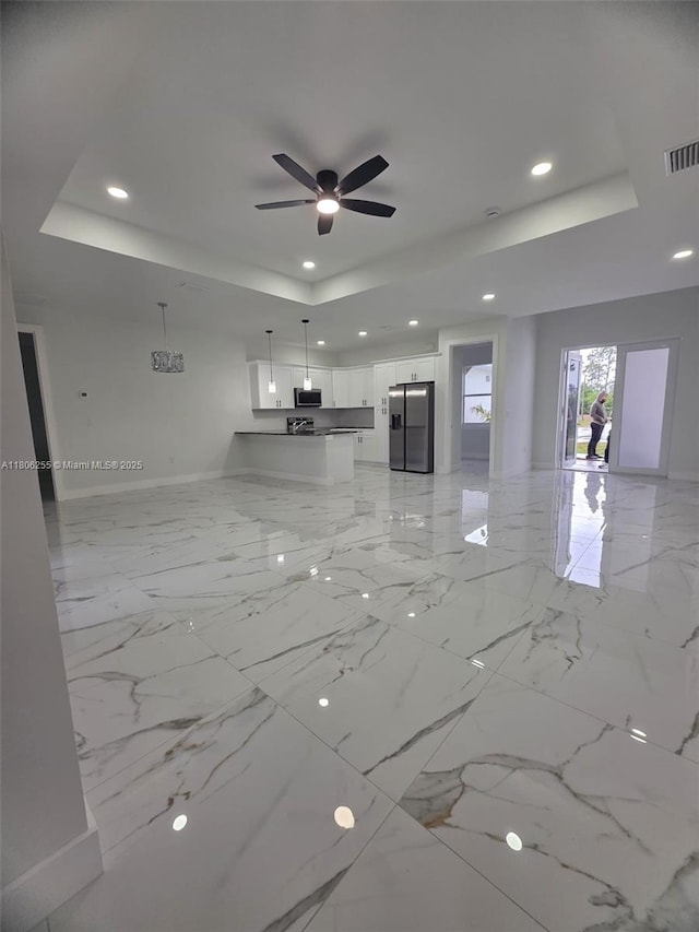 1145 SW Antonio St E, Lehigh Acres, FL 33974 - unfurnished living room with a tray ceiling, recessed lighting, and ceiling fan