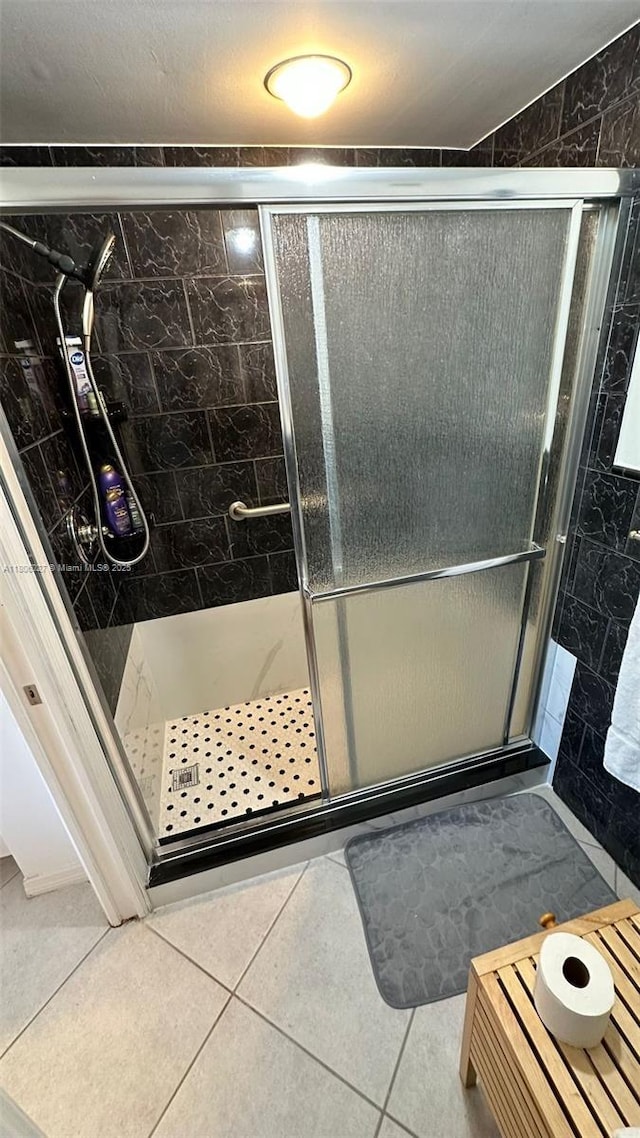 180 Seaview Ct Unit 706, Marco Island, FL 34145 - bathroom with tile walls, a shower stall, and tile patterned floors
