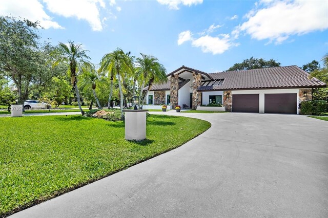 11850 SW 42nd Ct, Davie, FL 33330 - view of front facade with stone siding, a tiled roof, curved driveway, and a front yard