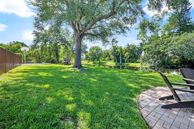 11850 SW 42nd Ct, Davie, FL 33330 - view of green lawn featuring a water view, view of scattered trees, and a patio area