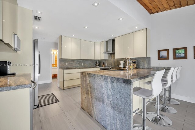 11850 SW 42nd Ct, Davie, FL 33330 - kitchen featuring wall chimney range hood, modern cabinets, a peninsula, baseboards, and decorative backsplash