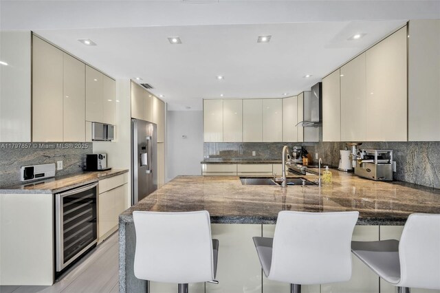 11850 SW 42nd Ct, Davie, FL 33330 - kitchen with beverage cooler, modern cabinets, stainless steel fridge, wall chimney range hood, and recessed lighting