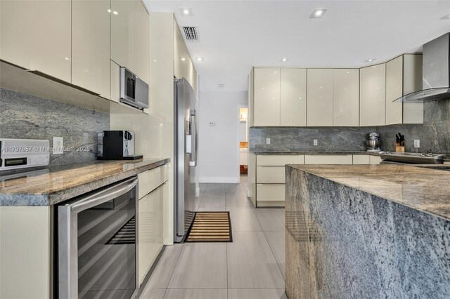 11850 SW 42nd Ct, Davie, FL 33330 - kitchen with modern cabinets, wine cooler, stainless steel appliances, wall chimney range hood, and tasteful backsplash
