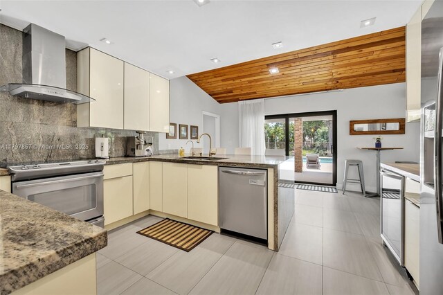 11850 SW 42nd Ct, Davie, FL 33330 - kitchen featuring stainless steel appliances, wall chimney exhaust hood, a sink, a peninsula, and decorative backsplash