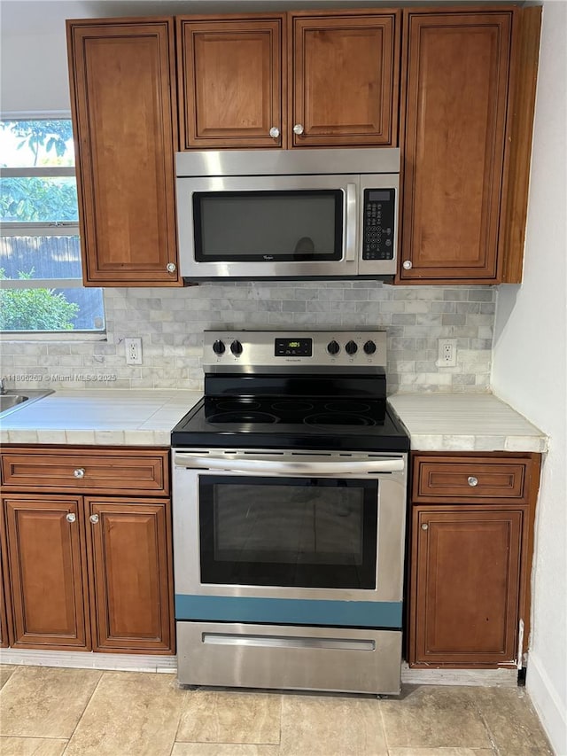 1416 SW 33ct, Fort Lauderdale, FL 33315 - kitchen featuring stainless steel appliances, tasteful backsplash, and brown cabinetry