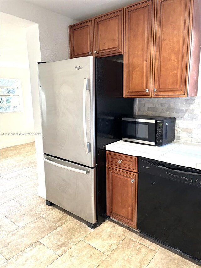1416 SW 33ct, Fort Lauderdale, FL 33315 - kitchen with black appliances, light countertops, brown cabinetry, and light stone finish flooring