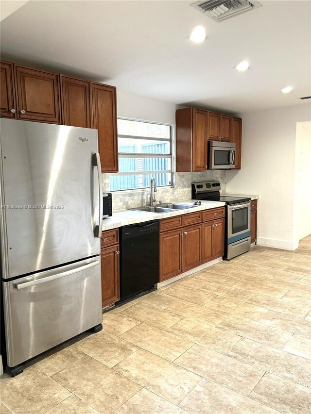 1416 SW 33ct, Fort Lauderdale, FL 33315 - kitchen featuring stainless steel appliances, backsplash, light countertops, a sink, and brown cabinets