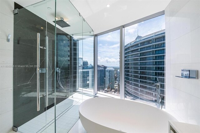 300 Biscayne Boulevard Way Unit 4507W, Miami, FL 33131 - full bathroom featuring a stall shower, a soaking tub, a view of city, and floor to ceiling windows