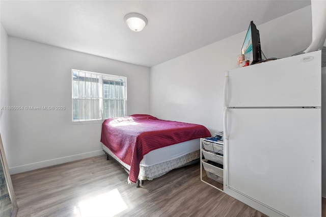 1812 NW 69th Ter, Miami, FL 33147 - bedroom featuring freestanding refrigerator, wood finished floors, and baseboards