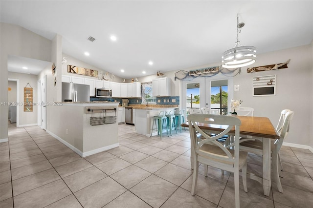 7434 Ashtabula St, Englewood, FL 34224 - dining room with vaulted ceiling, light tile patterned floors, french doors, a chandelier, and baseboards
