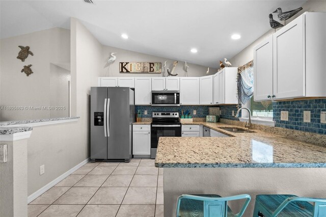 7434 Ashtabula St, Englewood, FL 34224 - kitchen with appliances with stainless steel finishes, a sink, lofted ceiling, decorative backsplash, and light stone counters