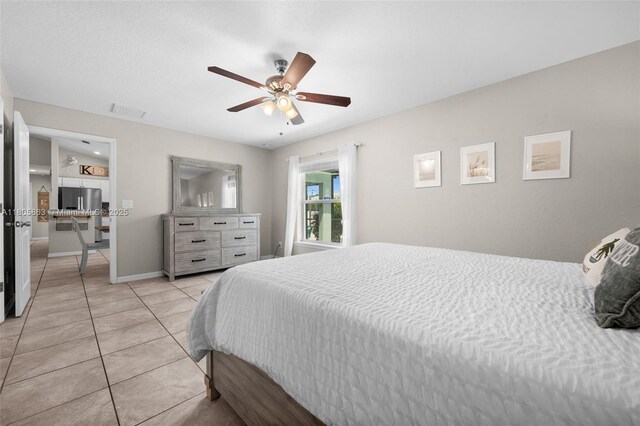 7434 Ashtabula St, Englewood, FL 34224 - bedroom with light tile patterned floors, a ceiling fan, baseboards, and stainless steel fridge