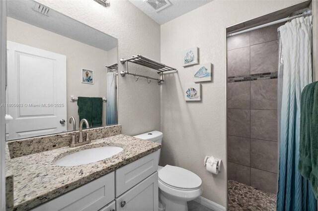 7434 Ashtabula St, Englewood, FL 34224 - bathroom featuring toilet, vanity, a tile shower, and a textured wall