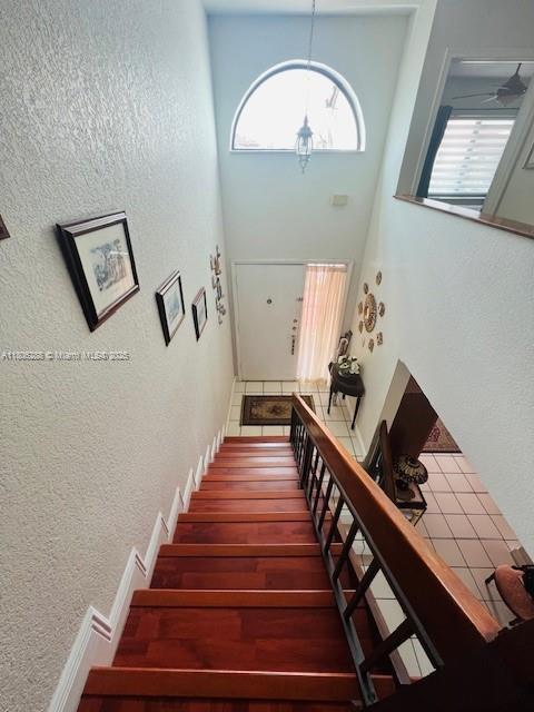 1271 SW 124th Ct Unit 2-D, Miami, FL 33184 - staircase with healthy amount of natural light, a textured wall, and a high ceiling