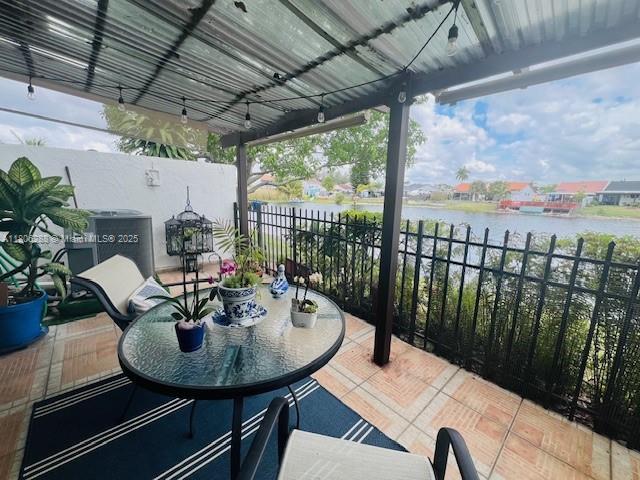 1271 SW 124th Ct Unit 2-D, Miami, FL 33184 - view of patio / terrace featuring a water view, fence, and outdoor dining space