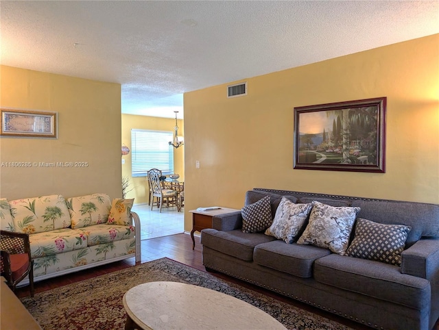 1280 NW 43rd Ave Unit 205, Lauderhill, FL 33313 - living area featuring wood finished floors, a chandelier, and a textured ceiling