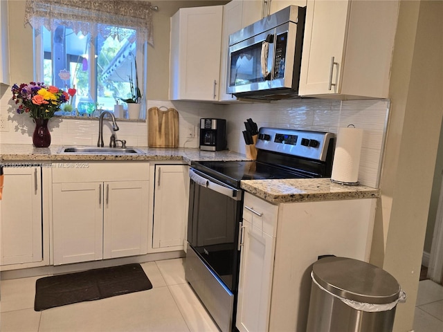 6626 SW 1st Ct, Pembroke Pines, FL 33023 - kitchen featuring appliances with stainless steel finishes, a sink, light tile patterned floors, white cabinetry, and backsplash