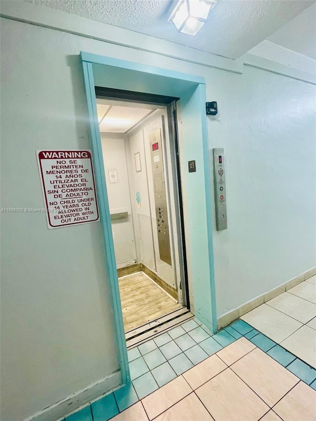 17101 NW 57th Ave Unit 314, Miami Gardens, FL 33055 - hallway with light tile patterned floors, a textured ceiling, and baseboards
