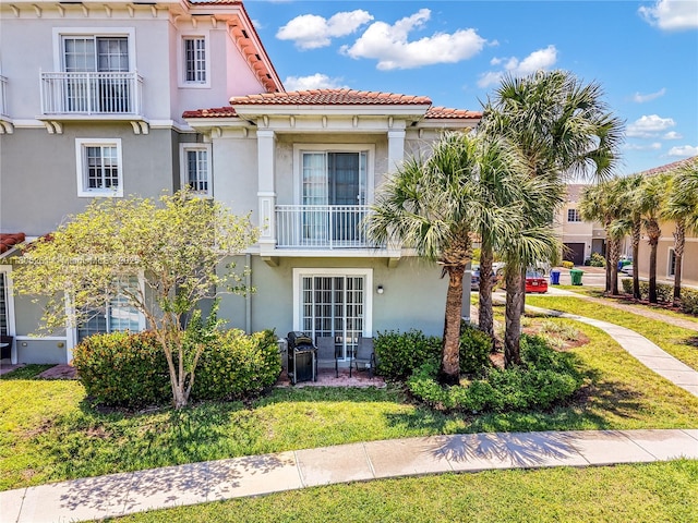2801 SW 81st Ter, Miramar, FL 33025 - view of front of house featuring a tile roof, stucco siding, a front yard, and a balcony