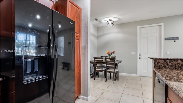 2801 SW 81st Ter, Miramar, FL 33025 - kitchen with black fridge, dark stone counters, stainless steel dishwasher, light tile patterned flooring, and baseboards