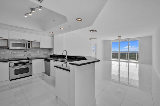 14951 Royal Oaks Ln Unit 2105, North Miami, FL 33181 - kitchen featuring stainless steel appliances, a sink, a peninsula, light tile patterned floors, and recessed lighting