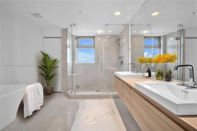 17301 Biscayne Blvd Unit 1108, Aventura, FL 33160 - bathroom with a stall shower, double vanity, healthy amount of natural light, a freestanding tub, and recessed lighting