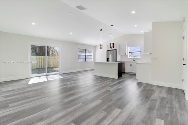 143 Greentree Cir, Jupiter, FL 33458 - unfurnished living room with lofted ceiling, light wood-type flooring, recessed lighting, baseboards, and a sink