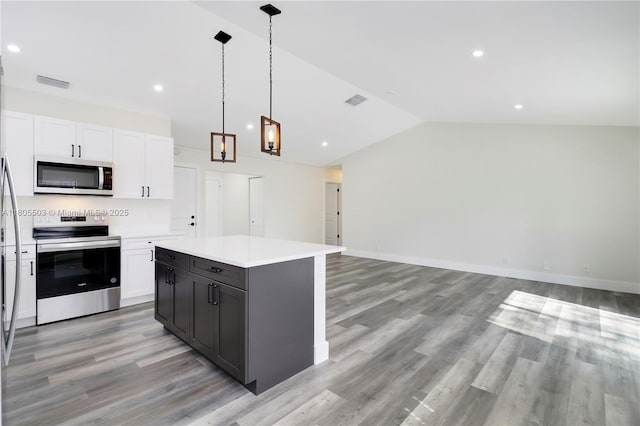 143 Greentree Cir, Jupiter, FL 33458 - kitchen featuring stainless steel appliances, light wood finished floors, white cabinetry, lofted ceiling, and light countertops