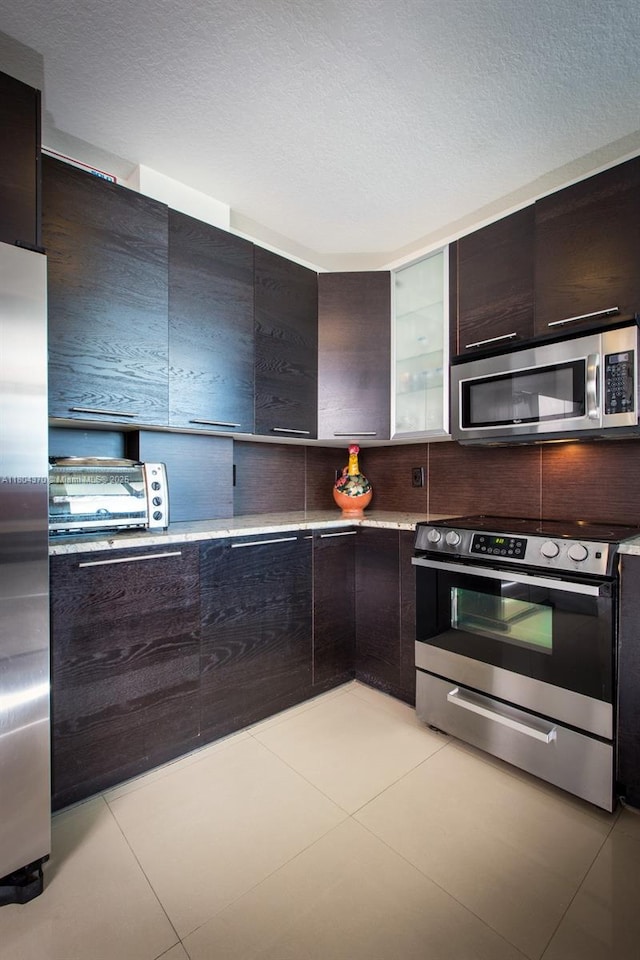 1250 S Miami Ave Unit 3106, Miami, FL 33130 - kitchen featuring appliances with stainless steel finishes, modern cabinets, light tile patterned floors, dark brown cabinets, and light countertops