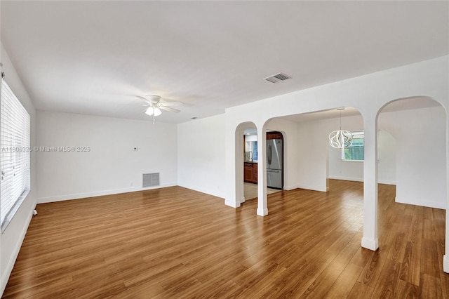 5861 NW 18th Ct, Sunrise, FL 33313 - unfurnished living room featuring ceiling fan, arched walkways, wood finished floors, and baseboards