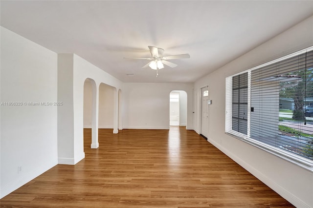 5861 NW 18th Ct, Sunrise, FL 33313 - unfurnished room featuring arched walkways, ceiling fan, light wood-style floors, and baseboards