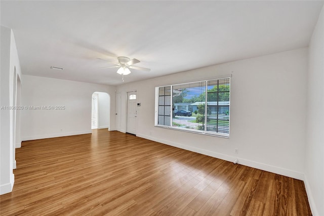 5861 NW 18th Ct, Sunrise, FL 33313 - empty room with arched walkways, a ceiling fan, baseboards, and light wood finished floors