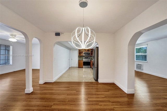 5861 NW 18th Ct, Sunrise, FL 33313 - unfurnished dining area featuring arched walkways, a chandelier, light wood-style floors, a ceiling fan, and baseboards