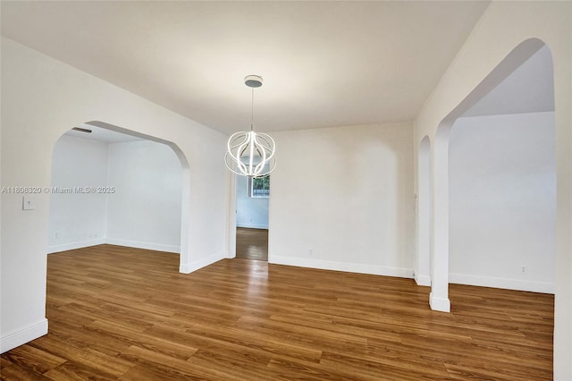 5861 NW 18th Ct, Sunrise, FL 33313 - unfurnished dining area featuring arched walkways, wood finished floors, a chandelier, and baseboards