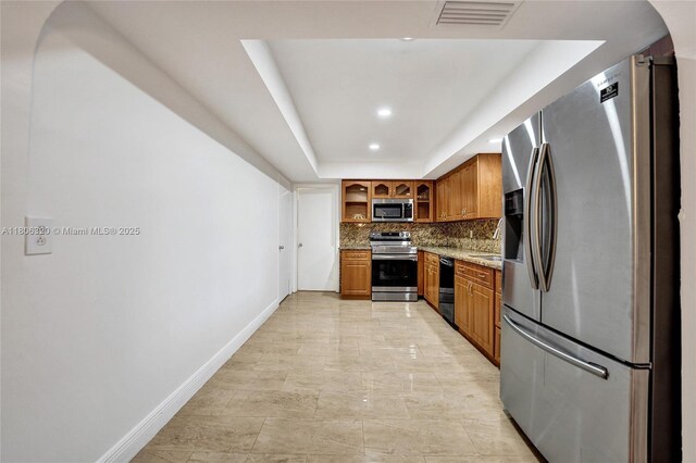 5861 NW 18th Ct, Sunrise, FL 33313 - kitchen with stainless steel appliances, brown cabinets, baseboards, backsplash, and glass insert cabinets