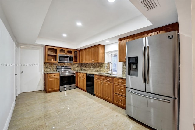 5861 NW 18th Ct, Sunrise, FL 33313 - kitchen with appliances with stainless steel finishes, a tray ceiling, brown cabinetry, decorative backsplash, and a sink