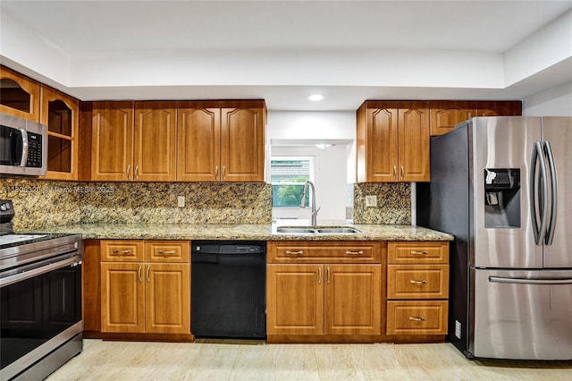 5861 NW 18th Ct, Sunrise, FL 33313 - kitchen featuring stainless steel appliances, a sink, light stone countertops, brown cabinets, and recessed lighting